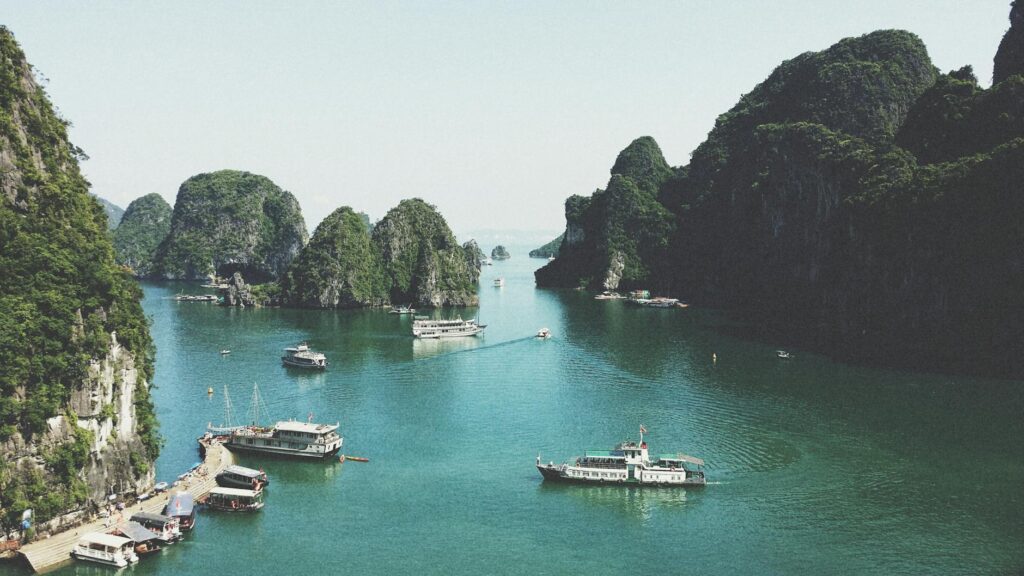 pexels-photo-58597-58597-3 A breathtaking view of Halong Bay with boats navigating through limestone islands.